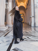 Black mink fur coat, side pose with long hem and high collar.