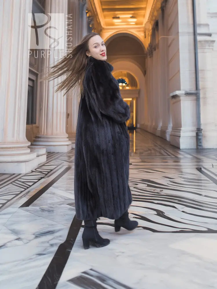 Black mink fur coat, side pose with long hem and high collar.
