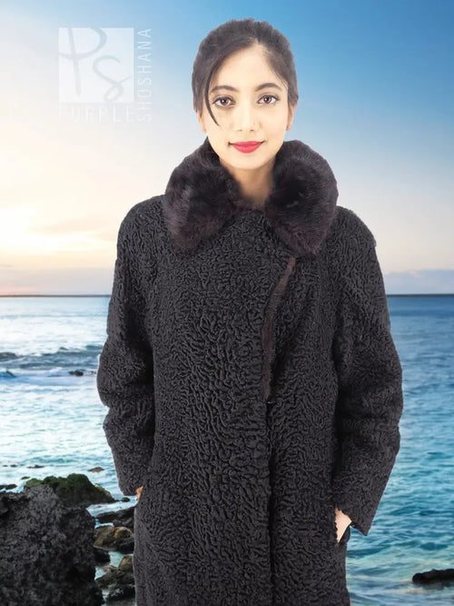 Black curly lamb coat with mink fur collar, front view close-up of textured fabric