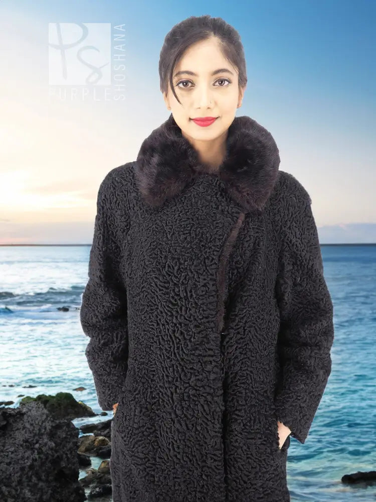 Black curly lamb coat with mink fur collar, front view close-up of textured fabric