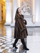 Brown mink fur swing coat with broad collar and long sleeves, above-knee length.