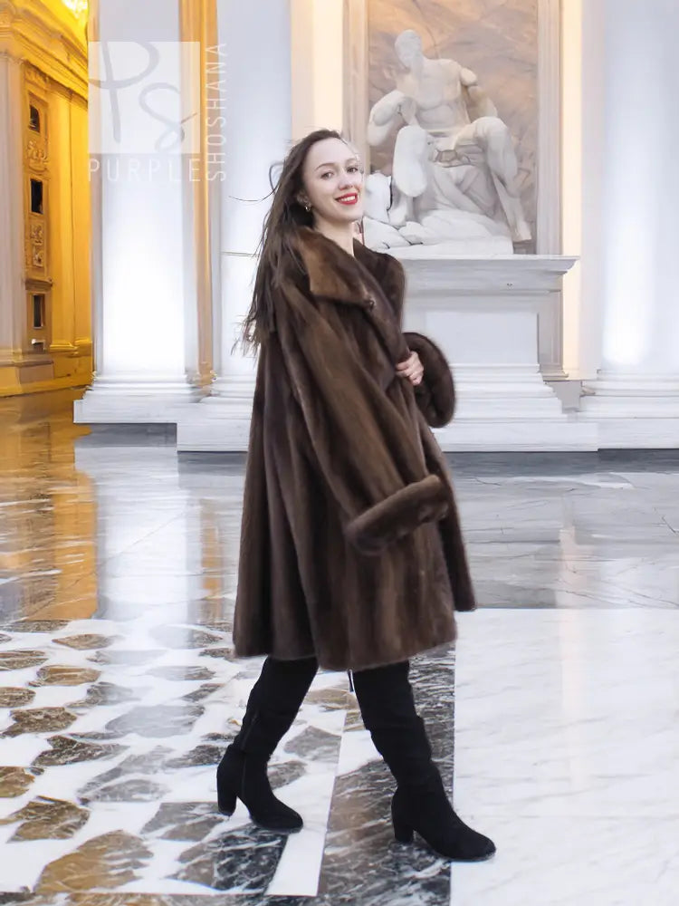 Brown mink fur swing coat with broad collar and long sleeves, above-knee length.