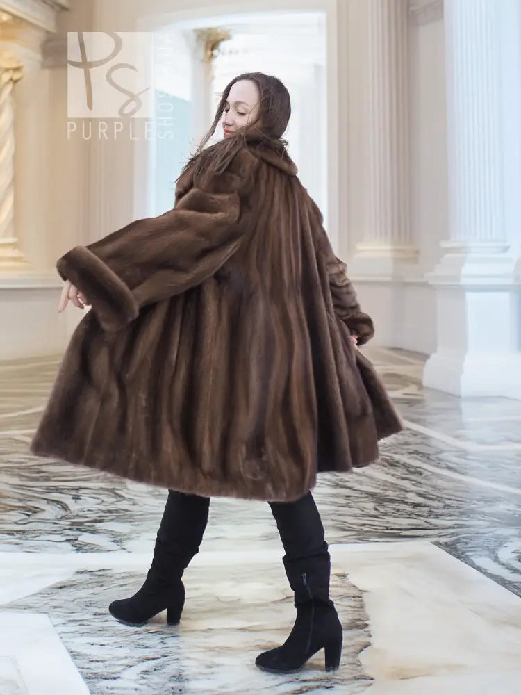 Dark brown mink fur swing coat, flared skirt shape and long sleeves with layered fur.