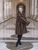 Dark brown fur coat with hood and layered collar, full-length profile.