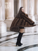 Dark brown fur coat with hood, flared hem, and three-quarter back view.