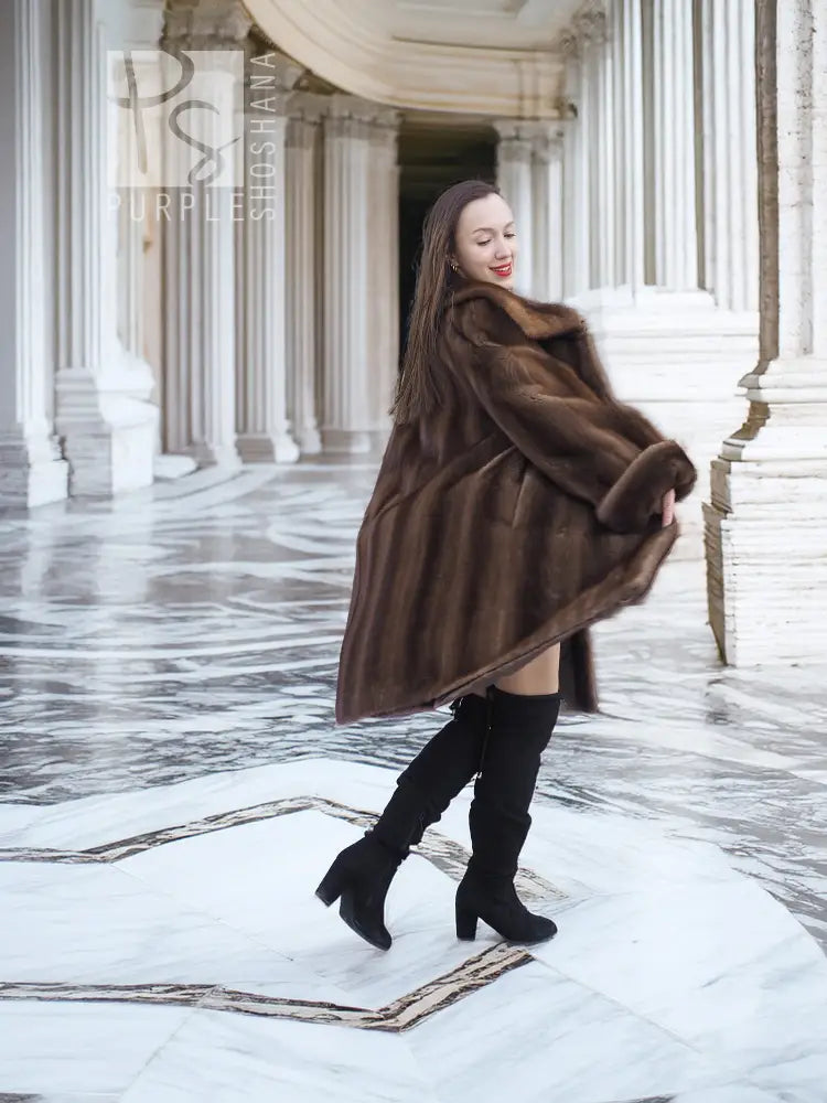 Dark brown mink fur swing coat with wide collar, short front hemline, and long sleeves.