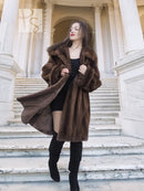 Dark brown mink fur coat with wide lapels and draped fur sleeves over a black top.