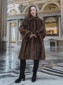 Brown mink fur coat with structured shoulders, wide cuffs, and full swing hem.