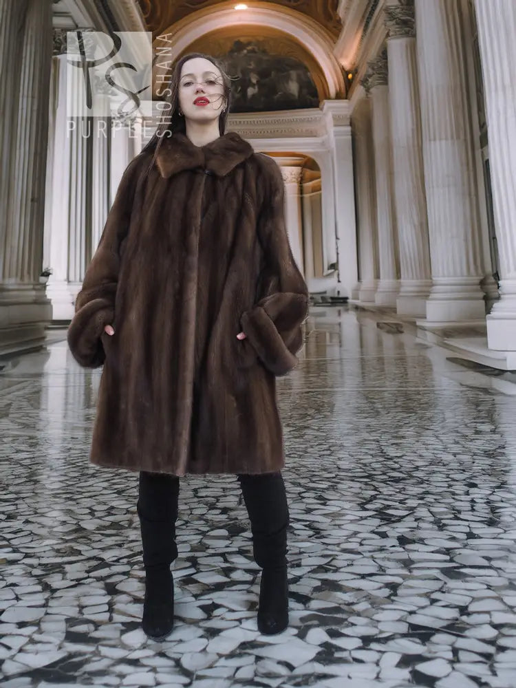 Dark brown fur hooded coat with side pockets and A-line swing shape.