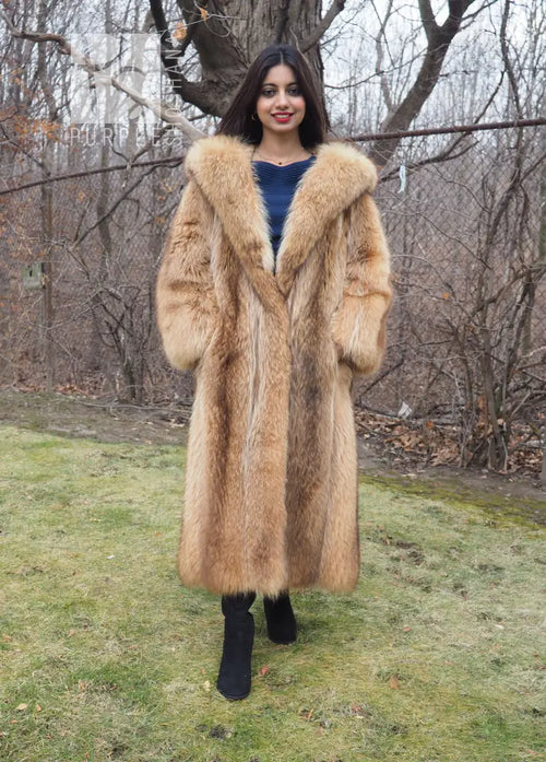 Tanuki raccoon fur coat with hood and open front, tan color, front view standing outdoors.