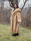 Tanuki raccoon fur coat with hood and long sleeves, tan fur, front three-quarter view.