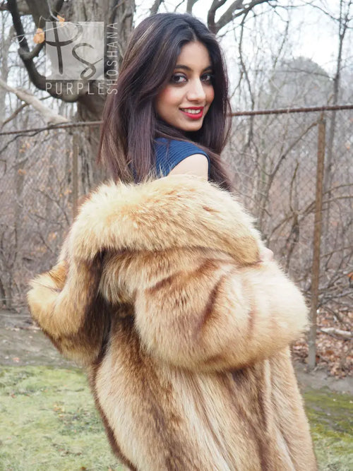 Tanuki raccoon fur coat close-up over shoulders, hood trim visible, tan plush fur texture.