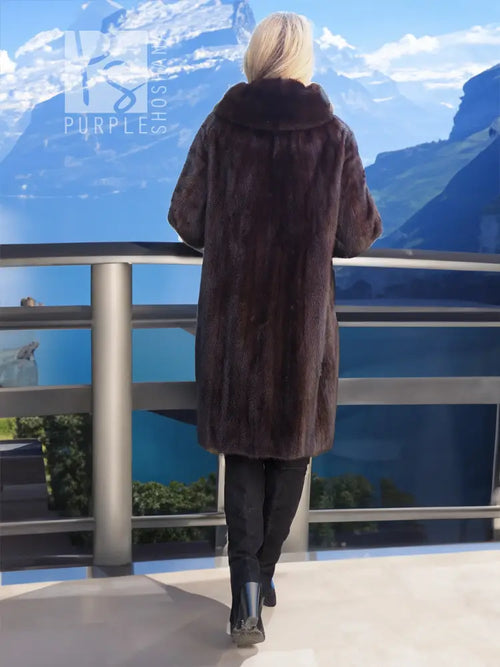 Dark mink fur long coat with high back collar, worn with dark pants and heels