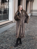 Long dark brown raccoon fur coat with open front and fitted sleeves, standing pose