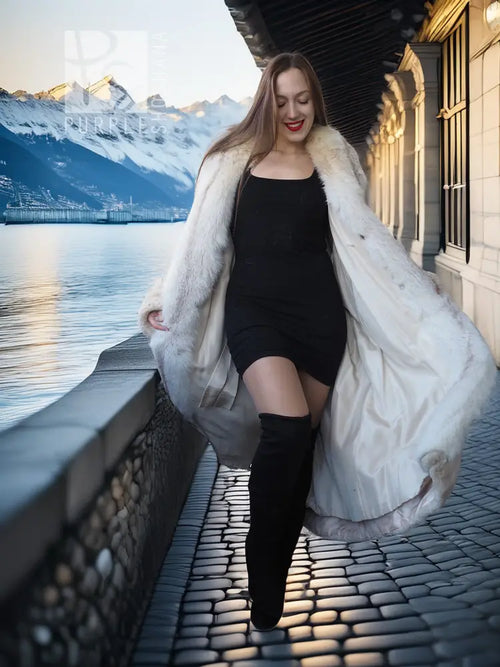 Long champagne fur coat worn over black dress, side view with flowing hem