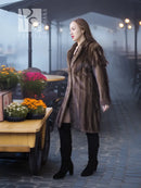 Mink fur coat in dark brown with long sleeves and open front, side view outdoors