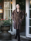 Mink fur coat in dark brown, knee-length with wide collar and structured shoulders