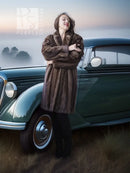 Mink fur coat in dark brown with long silhouette and open front, standing beside a car