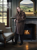 Mink fur coat in dark brown with long sleeves and open front, modeled indoors