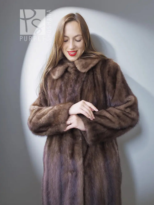 Mink fur coat close-up with stand collar and open front, brown, hands at waist