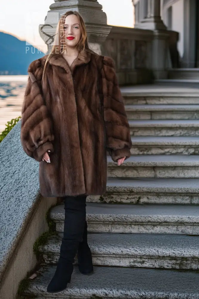 Brown mink fur jacket with structured shoulders, model standing on steps