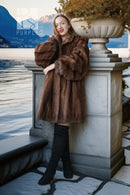 Brown mink fur jacket with full-length buttonless front and voluminous fur sleeves