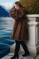 Brown mink fur jacket with plush fur texture, side view leaning on balcony