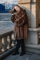 Brown mink fur jacket with oversized collar, model holding one arm across chest