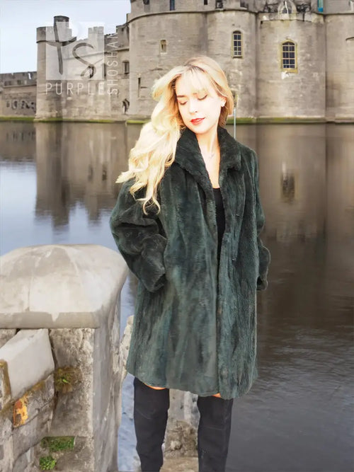Dark green beaver jacket front view with deep V neckline and draped sleeves