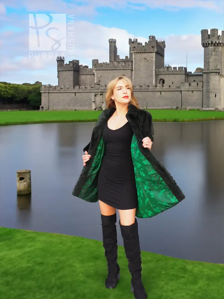 Dark green beaver jacket front with open drape and wide collar, worn over black dress