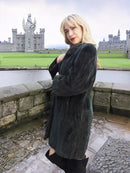 Dark beaver jacket with sheared plush texture, long sleeves and dark stand collar.