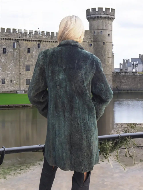 Back view of dark green sheared beaver jacket with draped hood and relaxed fit
