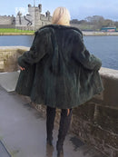 Dark green beaver jacket, back view, voluminous shoulders and long sleeves.