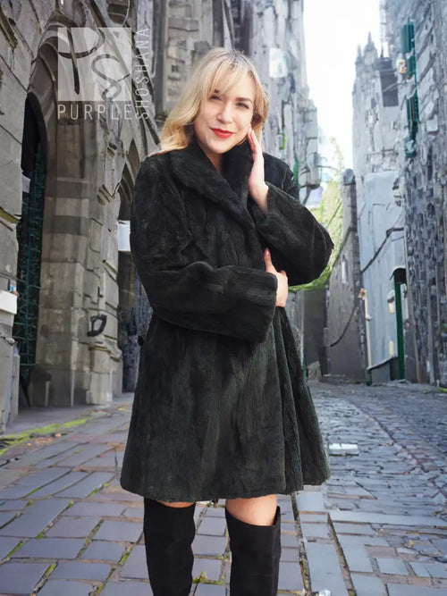 Dark sheared beaver jacket with long sleeves, stand collar, and draped front.