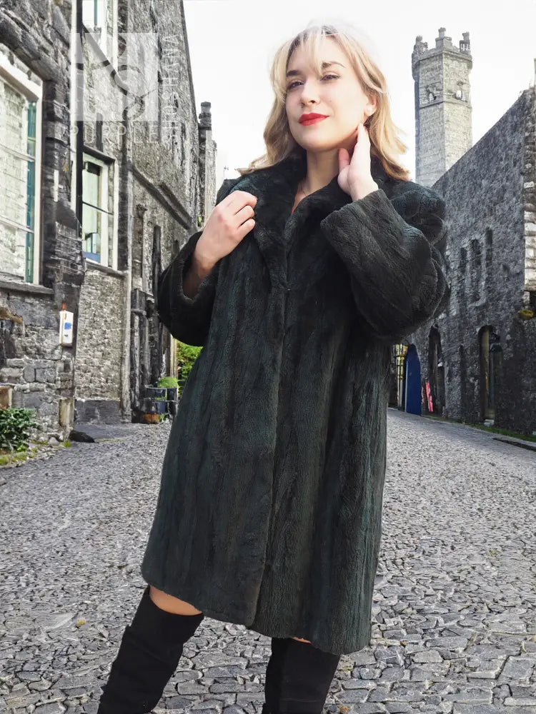 Dark beaver jacket with sheared plush texture, long sleeves, and raised collar.