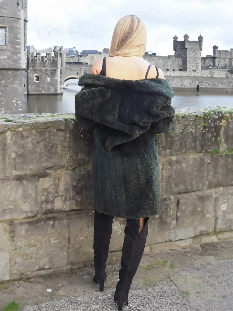 Dark green beaver jacket from behind with draped hood, long sleeves, and midi length