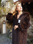 Dark mahogany-brown mink fur coat with shawl collar, side pockets, and tag on chest.