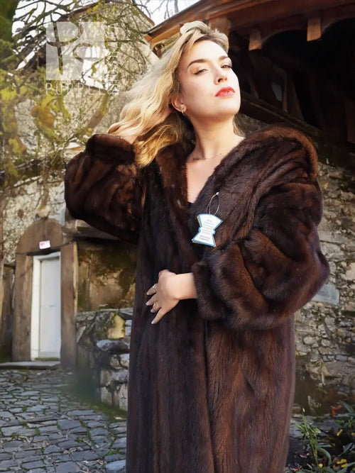 Dark mahogany-brown mink fur coat with shawl collar, side pockets, and tag on chest.