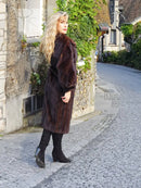 Dark brown mink fur coat with high collar, side profile view, long sleeves
