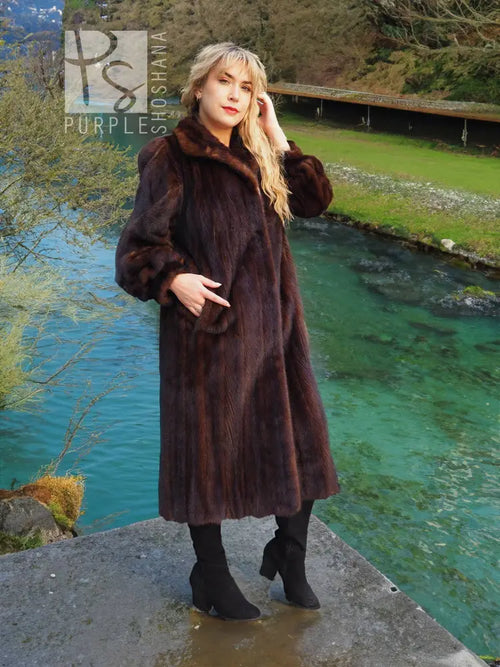 Long dark mahogany-brown mink fur coat with plush texture and side pockets.