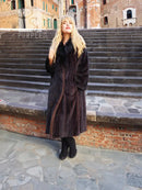 Black mink long coat with dark fur collar and button front, worn with dark boots
