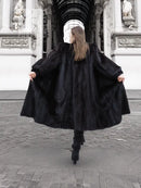 Black mink fur coat with wide flared hem, back and side view from behind