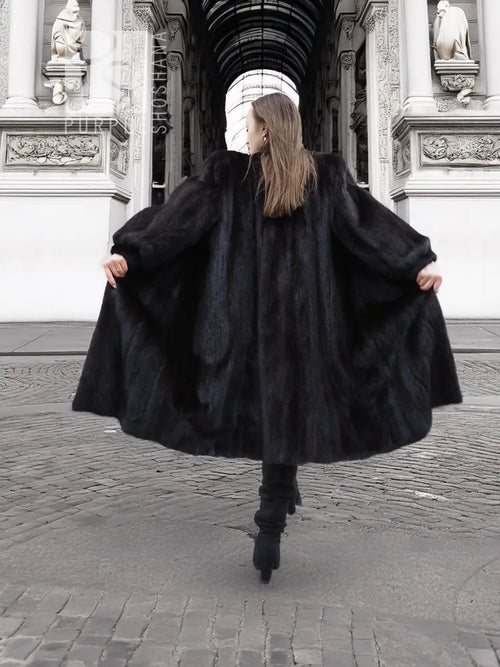 Black mink fur coat with wide flared hem, back and side view from behind