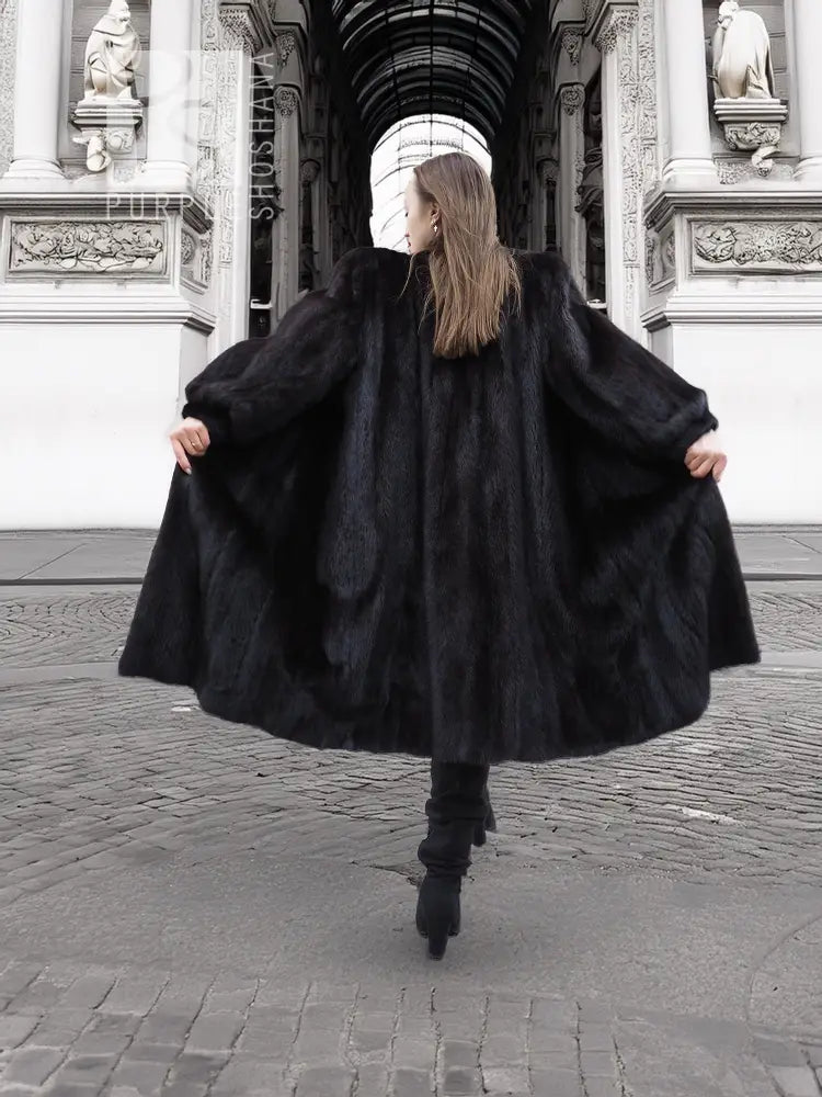 Black mink fur coat with wide flared hem, back and side view from behind
