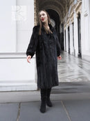 Black mink fur coat with long hem and sleeves, side profile view