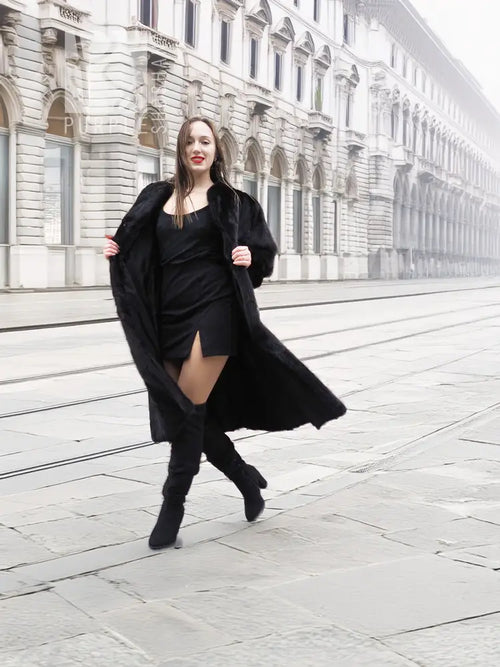 Black mink fur coat over black dress, front view with long flared coat hem