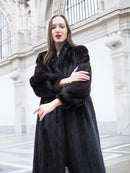 Black mink fur coat with textured fur, long sleeves and open front, arms crossed