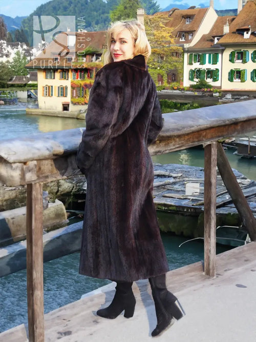 Long black mink fur coat with tall collar, fitted cuffs, and straight midi hem