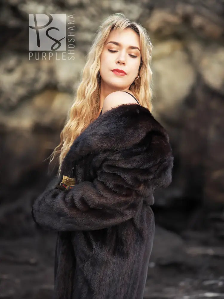 Black mink fur coat with hood, close-up of fur collar and shoulder.