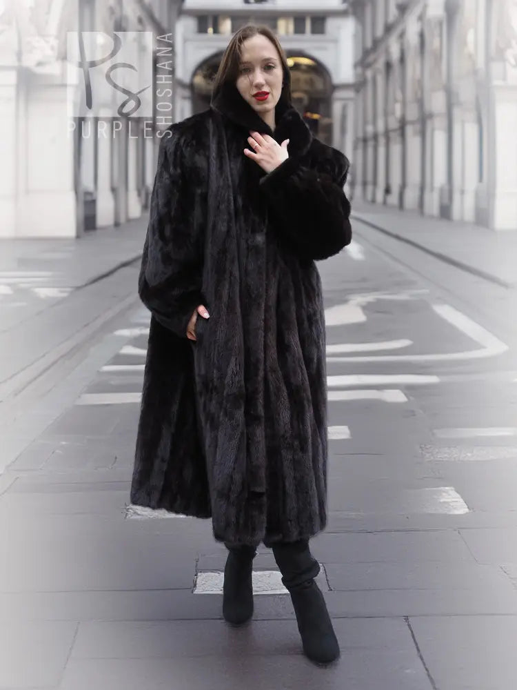 Black mink fur coat jacket with buttonless front and wide collar, walking front view.